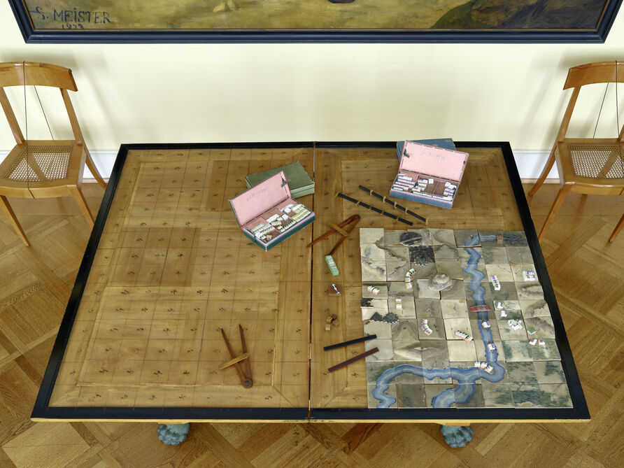 Domänen- und Kriegsrat Georg Leopold Baron von Reisswitz, Kommode „Taktisches Kriegs Spiel" für Friedrich Wilhelm III., 1812: Blick auf das teilweise mit Spielsteinen bestückte Spielfeld. Aus konservatorischen Gründen können Besuchende vor Ort leider nur die geschlossene „Spielkommode“ betrachten.