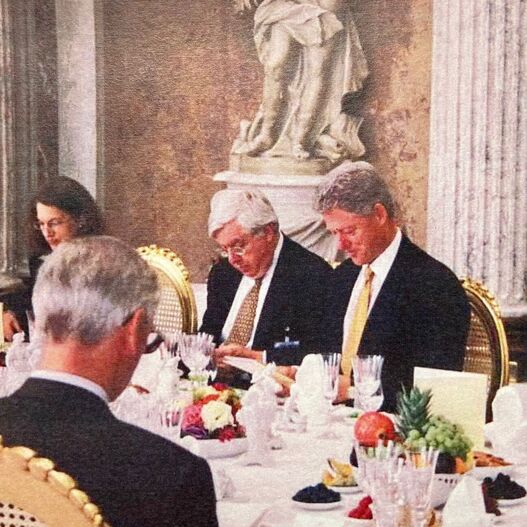 US-Präsident Bill Clinton studiert die Menüfolge des Mittagessens, neben ihm US-Botschafter John Kronblum.