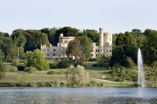 Blick vom Wasser über den Geysir auf das Schloss Babelsberg und den Park Babelsberg