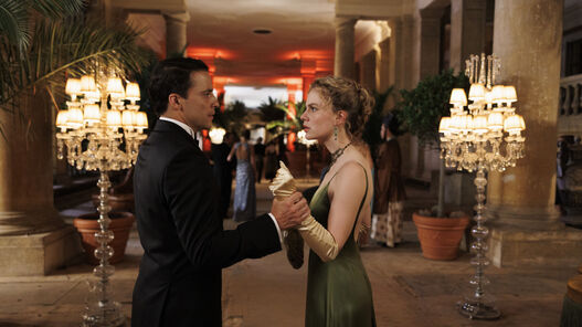 Butler James (Kostja Ullmann, links) und Miss Sophie (Alicia von Rittberg, rechts) auf einer Party in der Pflanzenhalle des Orangerieschlosses