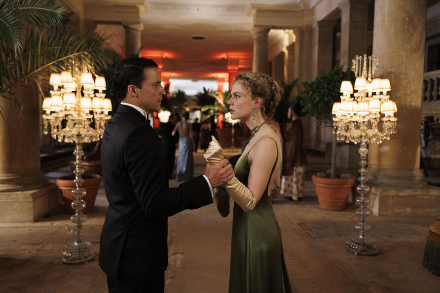 Butler James (Kostja Ullmann, links) und Miss Sophie (Alicia von Rittberg, rechts) auf einer Party in der Pflanzenhalle des Orangerieschlosses