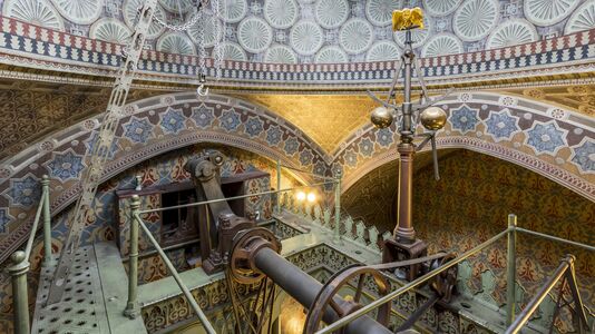 Maschinenraum des Dampfmaschinenhauses (Moschee) mit kunstvoll verziertem Gewölbe und Metallgestänge. Dampfmaschine in der Mitte. Reiche Muster und Ornamente bedecken Wände und Decke.