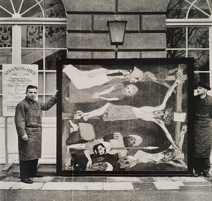 Zwei Angestellte des Kunstdienstes präsentieren Emil Noldes „Kreuzigung“ (Mittelteil des neunteiligen Gemäldes „Das Leben Christi“), 1912, Öl auf Leinwand, 220,5 × 193,5 cm (Wvz. Urban 477) vor dem Schloss Schönhausen, Foto: Günter Ranft (vermutlich)