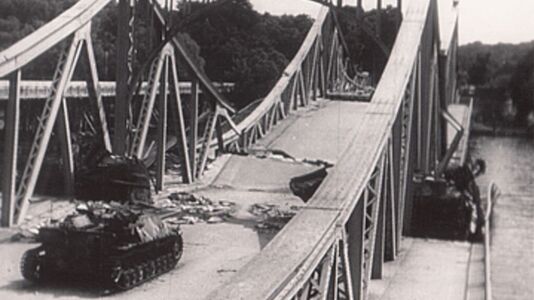 Blick von Potsdam auf die zerstörte Glienicker Brücke mit einem liegengebliebenen deutschen Panzer (Sturmgeschütz IV oder Jagdpanzer IV), Standbild aus dem Film „Potsdam baut auf“ (DEFA, 1946, Regie: Joop Huisken)