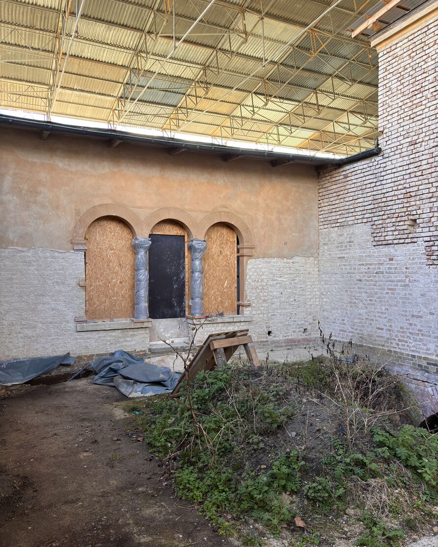 Innenhof mit Blick auf die teilweise zugemauerten Rundbögen des gegenüberliegenden Viridariums