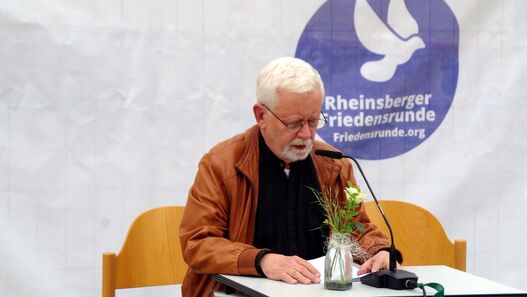 Lesen gegen das Vergessen: Mann sitzt am Tisch und liest etwas vor