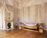 Schlafzimmer der Königin Luise im Neuen Flügel mit Bett, Kamin und drapierten Vorhängen an den Wänden